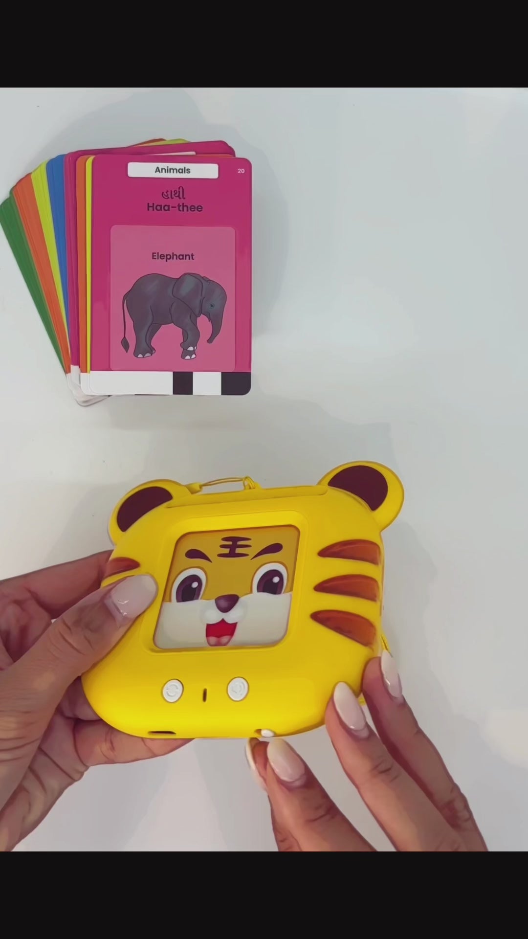Sheru the Tiger in action — child inserting flashcard into screen-free Indian language learning toy and hearing the word spoken aloud in Gujarati